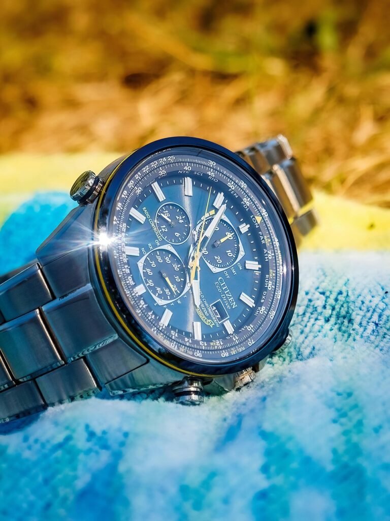 Best hiking GPS watch 2025. Black solar powered watch resting on blue cloth outdoors.