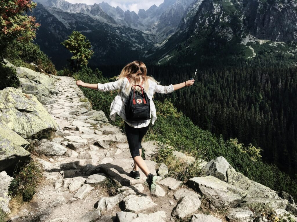 Woman on instagram hiking along rocky path in Vysoké Tatry, Slovakia. Embracing nature and freedom.